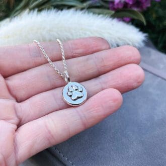 sterling silver paw print necklace in hand