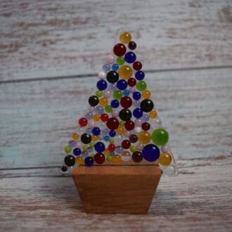 unique handmade glass multicoloured Christmas tree on a wooden stand