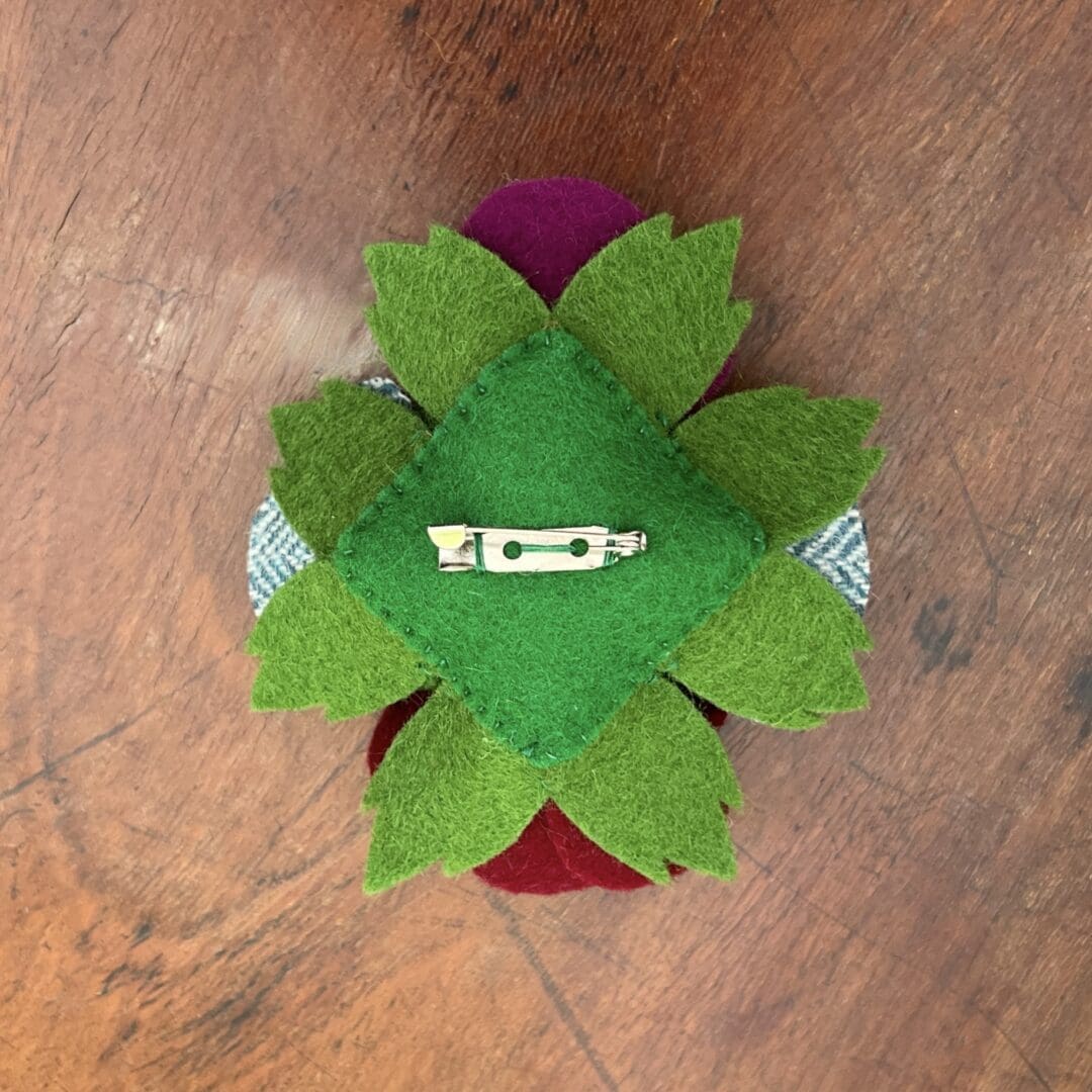 The picture shows the back view of a wool felt brooch.