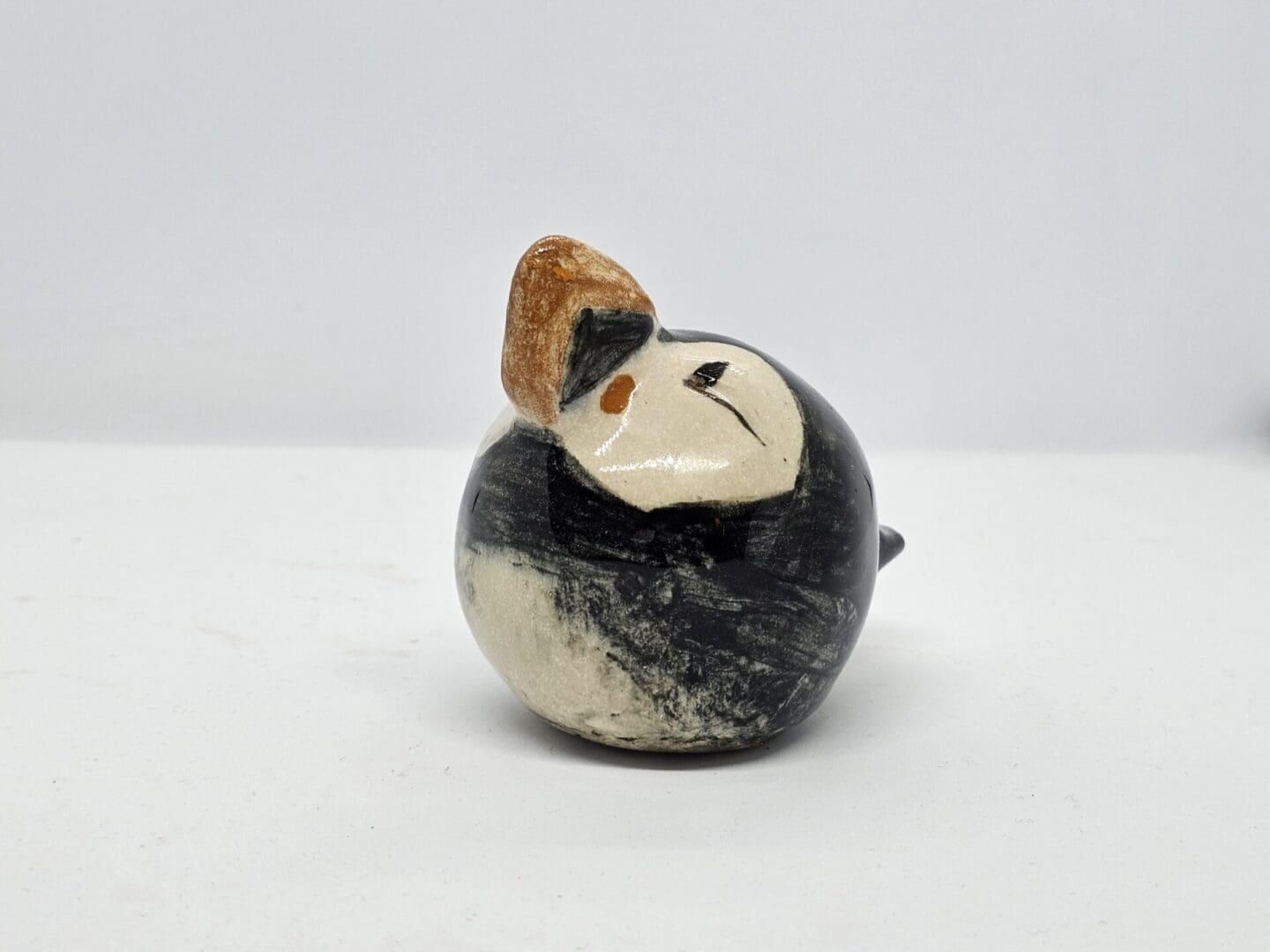 On a white background, a front-left facing view of a ceramic puffin