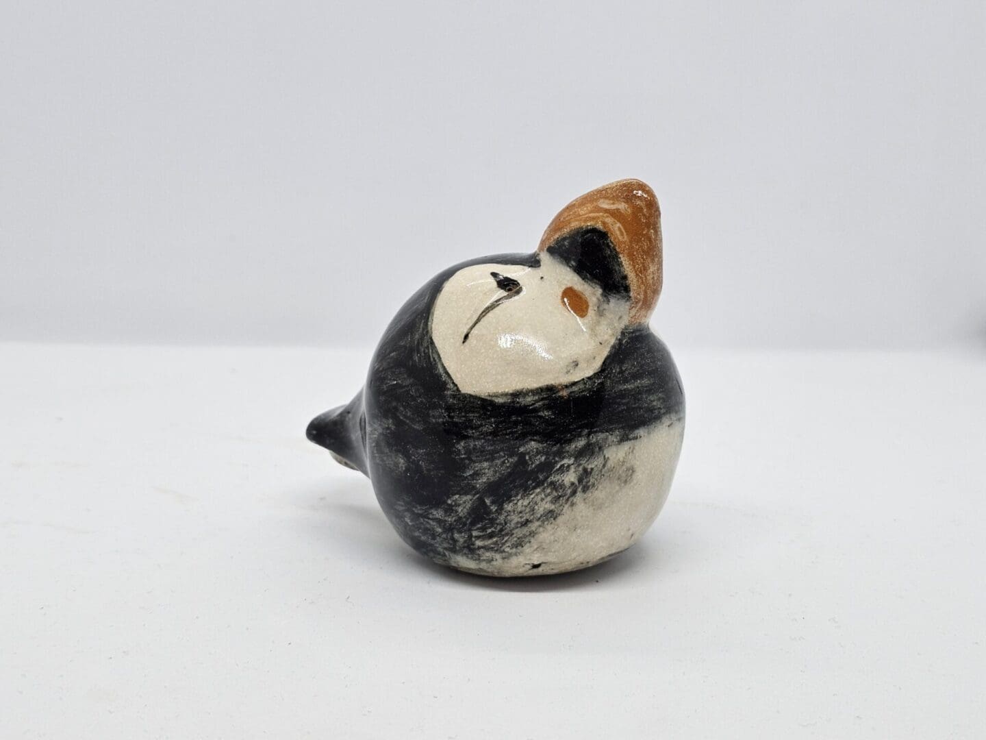 On a white background, a front-right facing view of a ceramic puffin