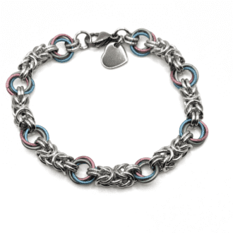 A chainmaille bracelet made with sections of byzantine weave in silver connected with pastel coloured larger rings in pastel colours