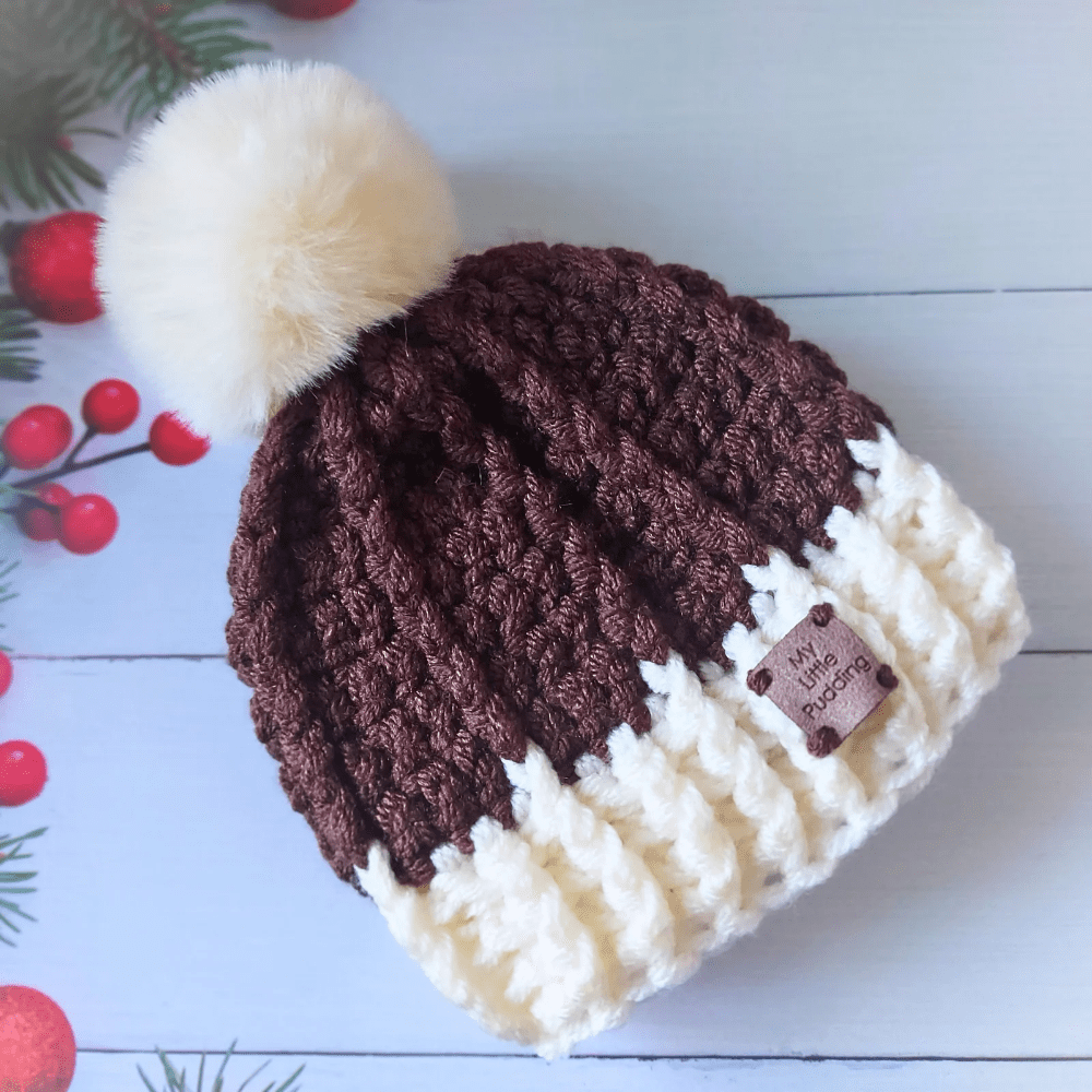 Christmas pudding themed chunky pom pom beanie baby hat, made in dark brown with a cream ribbed headband and a cream pom pom