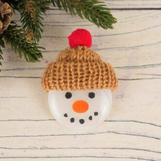 Handmade fused glass snowman head brooch with painted face and woolly knitted hat