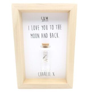 Small wood frame with a glass bottle containing a silver moon and stars charm in the centre, with a personalised I love you to the moon and back quote