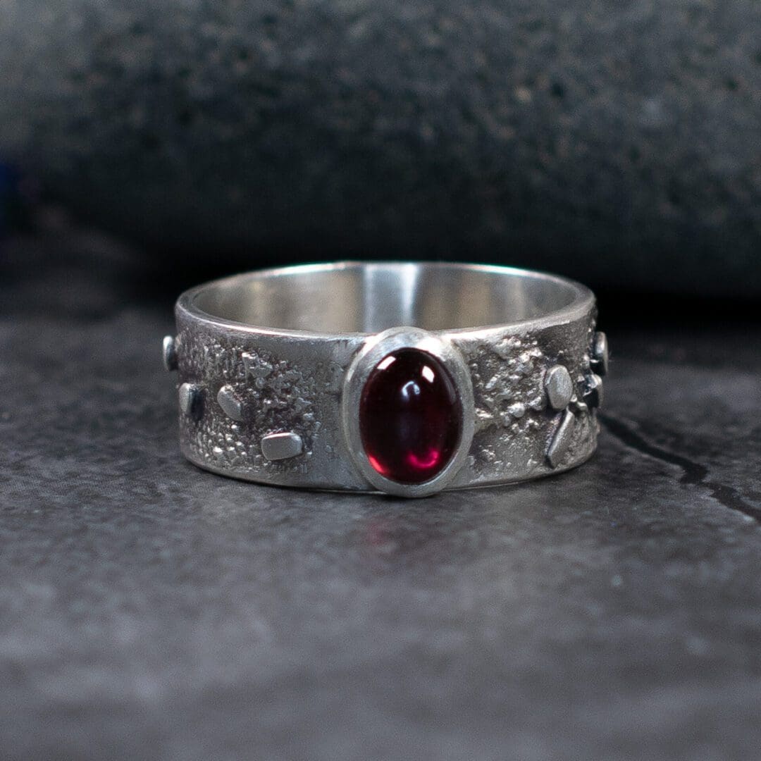 Textured Silver band ring with an Oval Garnet Gemstone. Artisan finish handmade in Argentium Sterling Silver.