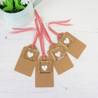 Four Kraft gift tags each with a handmade fused glass and paper cut heart keepsake