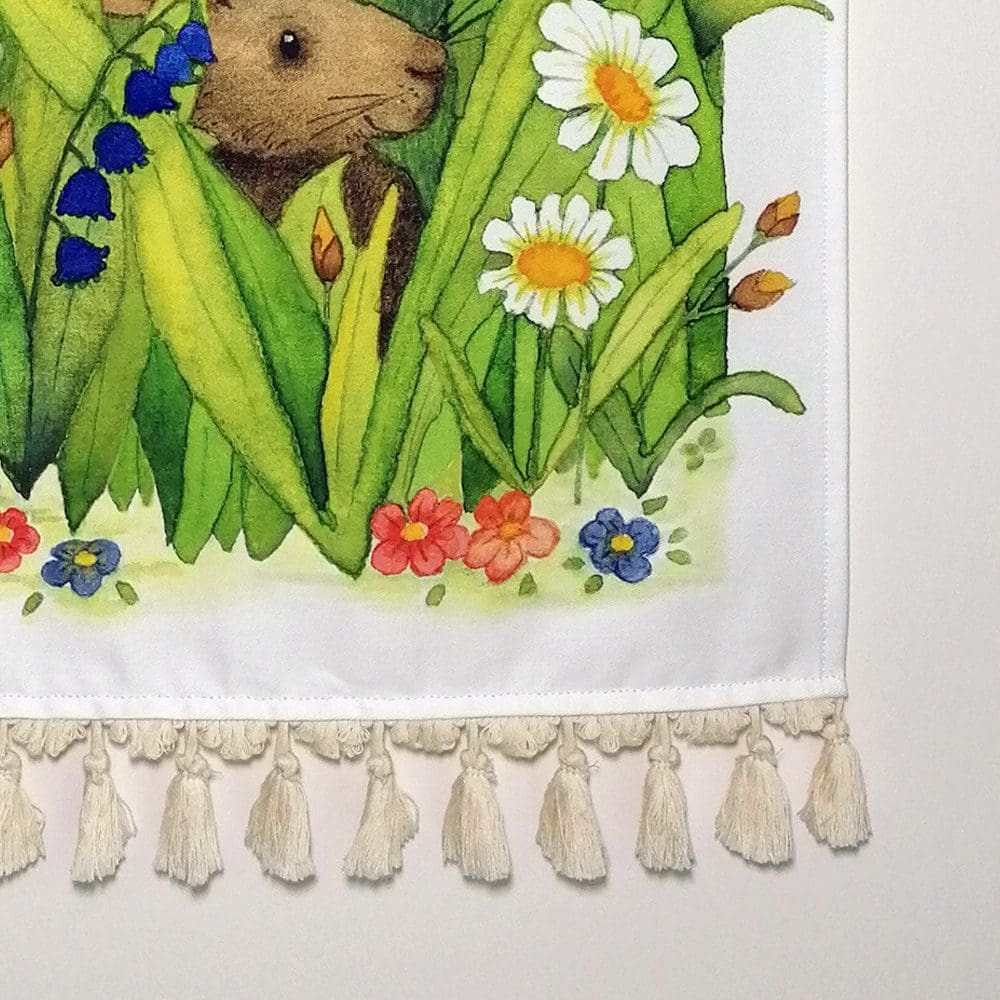 Close up detail of the rabbits wall hanging - printed cotton fabric and pale cream tassels. Original illustration created as a watercolour painting.