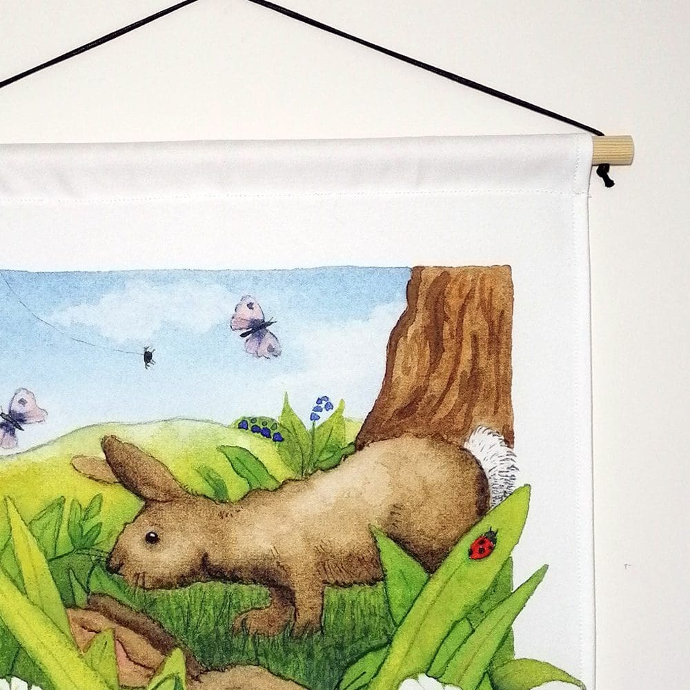 Close up detail of the rabbits wall hanging - wooden pole hanger and waxed cotton chord. Original illustration created as a watercolour painting.