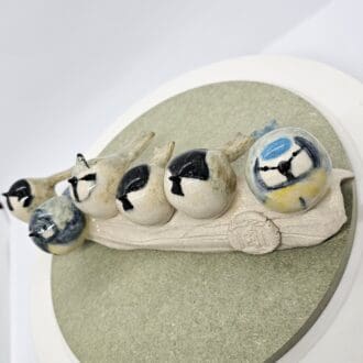 Ceramic model of a tree branch with (left to right) coal tit, great tit, crested tit, marsh tit, willow tit, blue tit