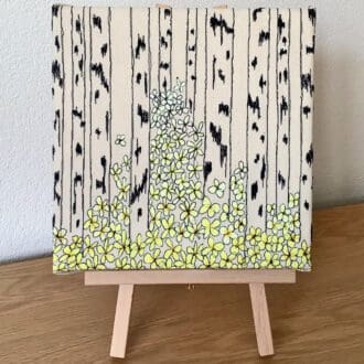 Embroidered picture of birch trees and yellow spring flowers
