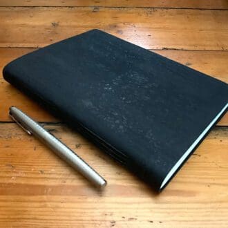 Ink blue A5 soft cover cork journal with exposed stitching and plain paper