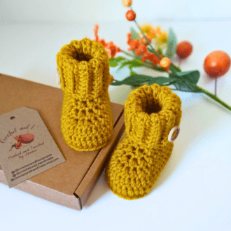 Mustard yellow coloured crochet baby booties with a ribbed folded cuff and finished off with a handmade with love wooden in sizes newborn, 0-3 and 3-6 monthsbutton