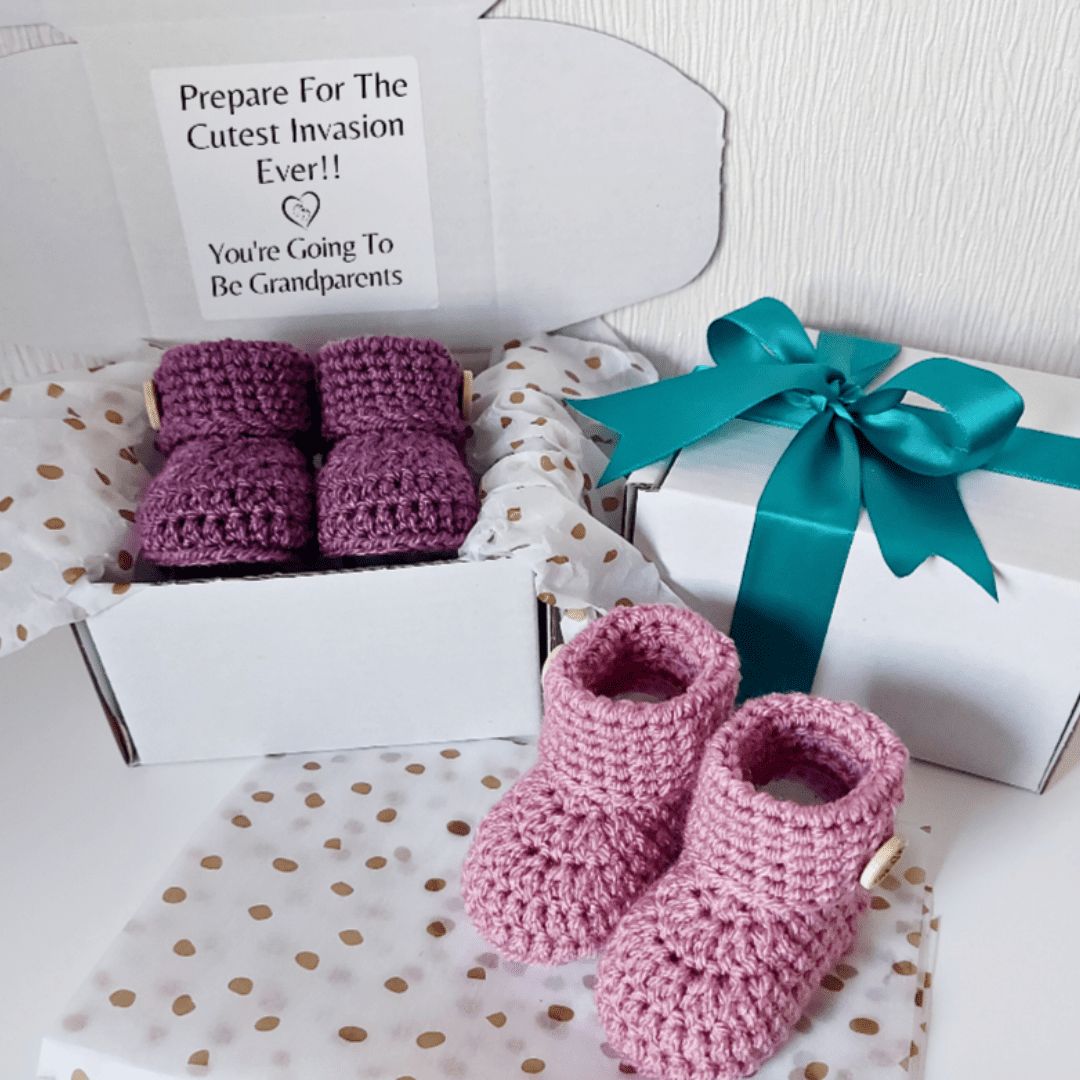 Pregnancy reveal announcement idea for gifting to grandparents to be, a pair of newborn hand crochet baby booties, displayed in a gift box with tissue paper