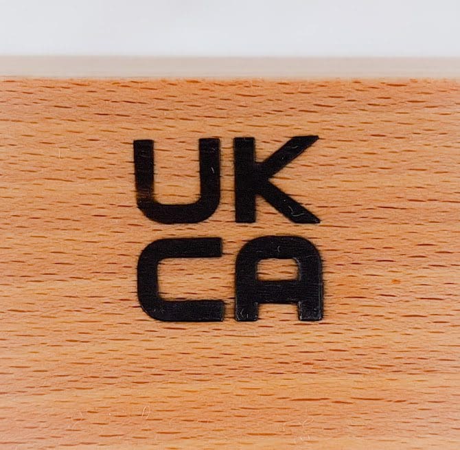 Close up of the UKCA mark branded on the rocker of an Ambel dolls cot