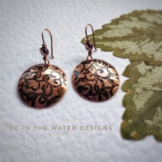 copper embossed dangly round domes painted in black