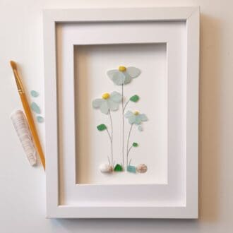 framed picture of three pale blue sea glass flowers