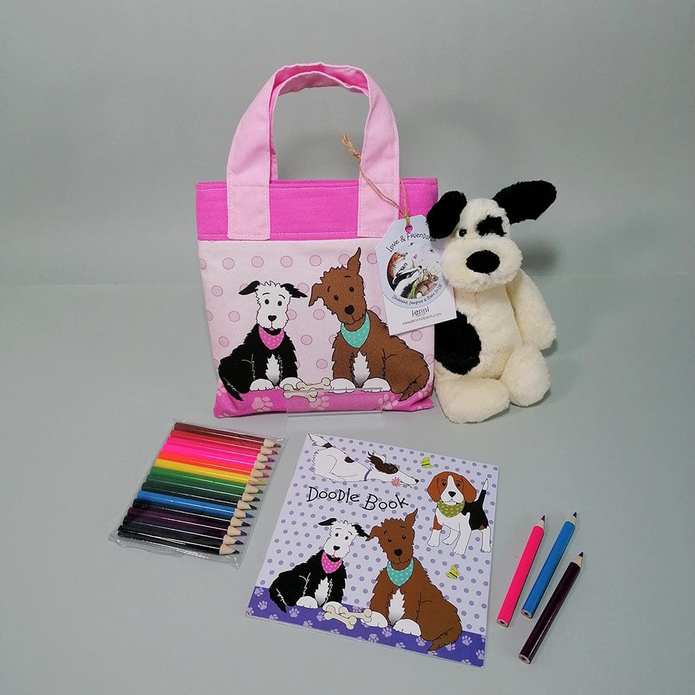 Cute pale and dark pink cotton bookbag with water resistant lining featuring two sweet dogs illustration. The bag contains a stapled blank 20 page sketchbook featuring a selection of dogs and furry friends, 14 mini colouring pencils with a laminated bookmark printed with a cat and mouse theme. Ideal for kids who love to draw.