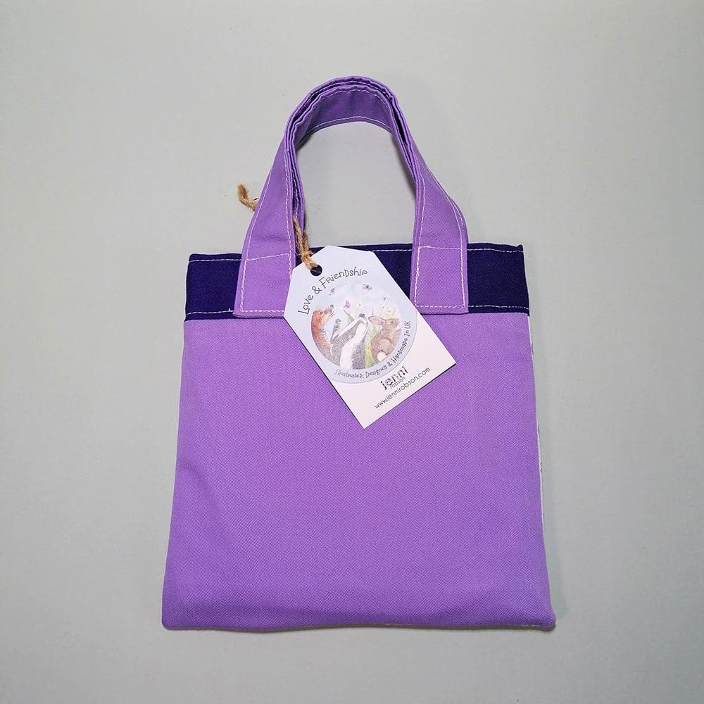 Back view of the mini bookbag in two shades of purple cotton fabric. Lined with water resistant lining