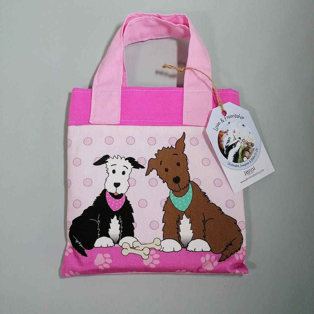 Detail of the pink mini bookbag front featuring two dogs sitting with their bones