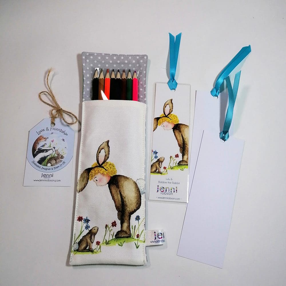 Handmade cotton pouch containing 8 colouring pencils, a laminated, printed bookmark and two blank bookmarks ready to be coloured with satin ribbon decoration. Set features Lulu and Bobbie rabbit