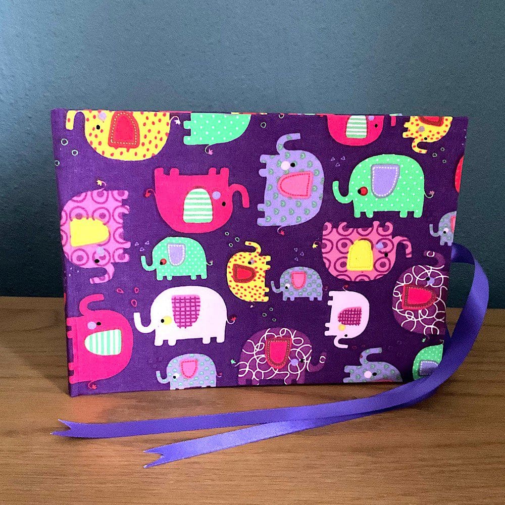 A5 Landscape Baby Photo Album covered in a purple and pink elephant print on purple background