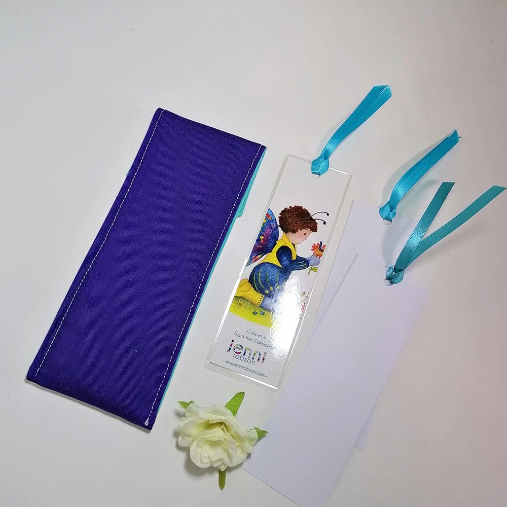 Handmade cotton pouch containing 8 colouring pencils, a laminated, printed bookmark and two blank bookmarks ready to be coloured with satin ribbon decoration. Set features Casper and Frank the caterpillar
