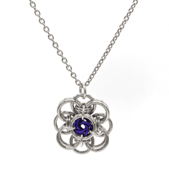 a chainmaille pendant made in the shape of a flower. The petals are made from silver coloured rings and there are smaller purple rings in the centre