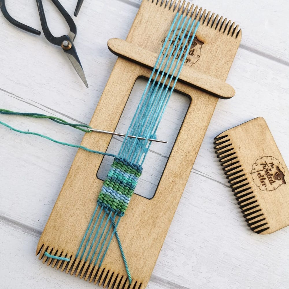 mini weaving loom with scissors and green thread