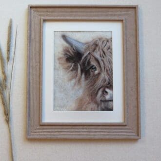 An original handmade needle felted wool picture of a highland cow in a ribbed, mid-brown wood effect frame.