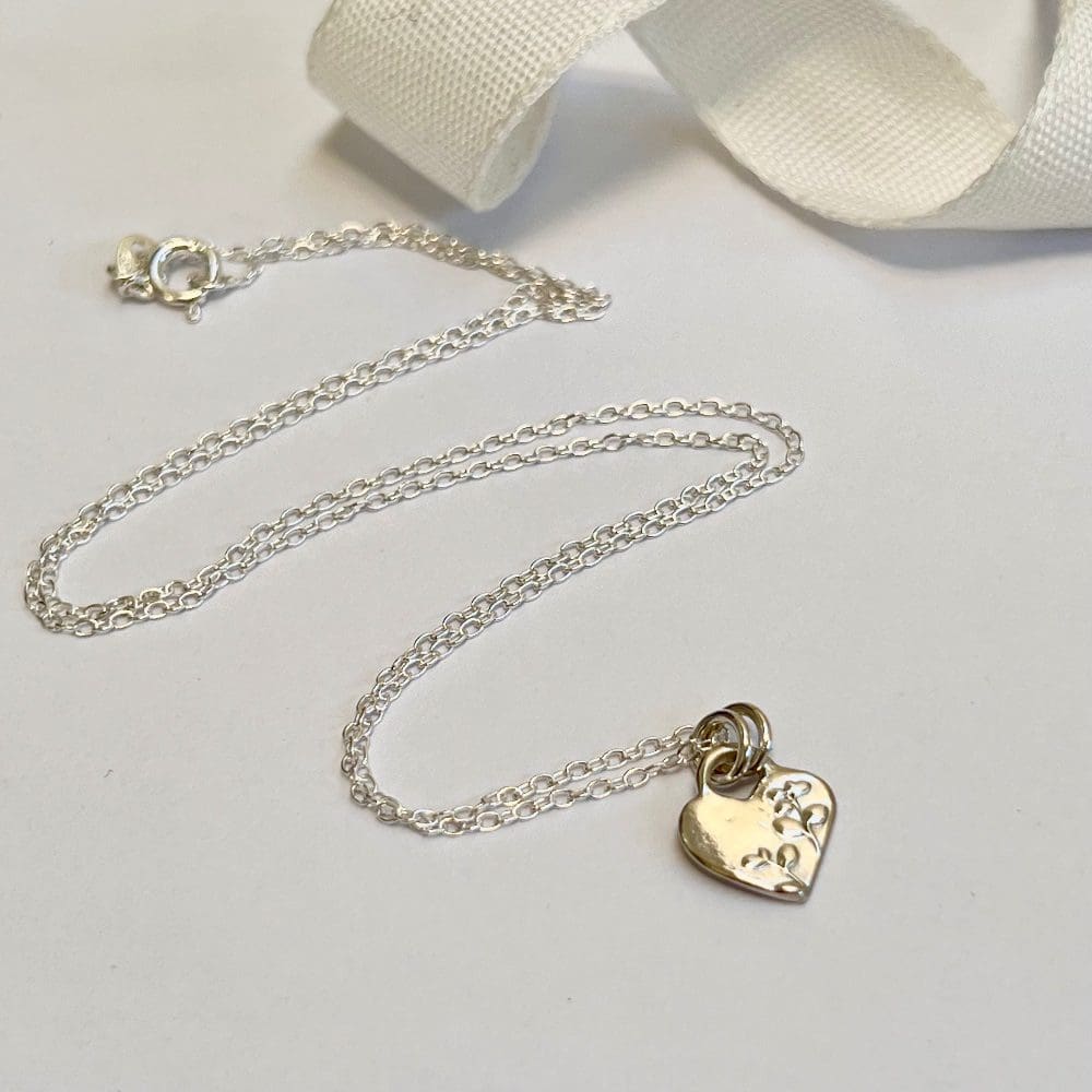 Dainty silver heart necklace with blossom flower texture