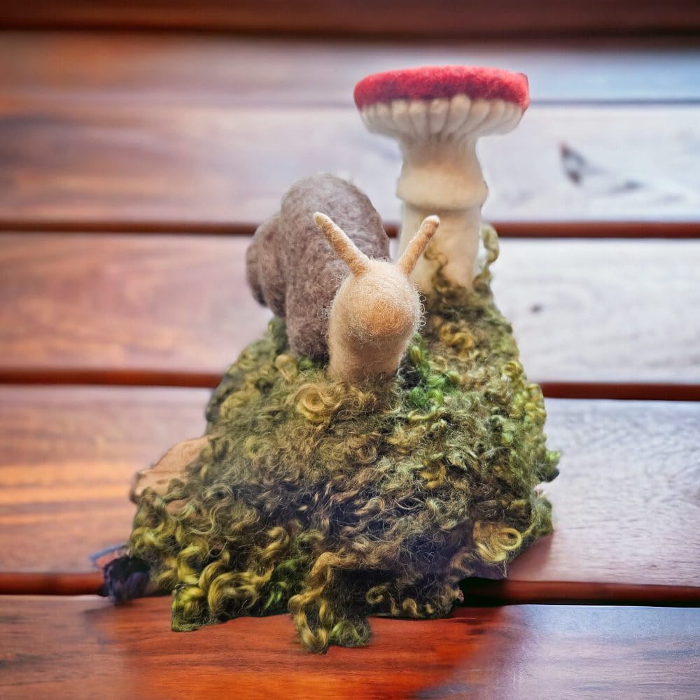 Side view of needle felted snail with toadstool