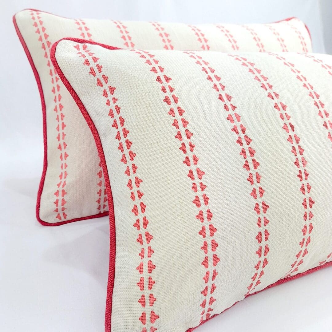 Two rectangular cushions made from Vanessa Arbuthnott Simple Ticking in Soft Raspberry with matching piped edge and back