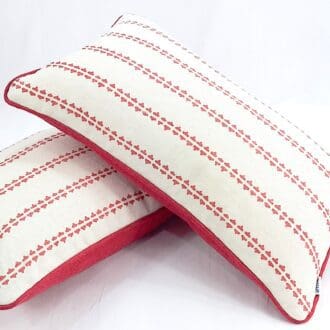 Two rectangular piped cushions made using Vanessa Arbuthnott Simple Ticking in Soft Raspberry with a concealed zip.