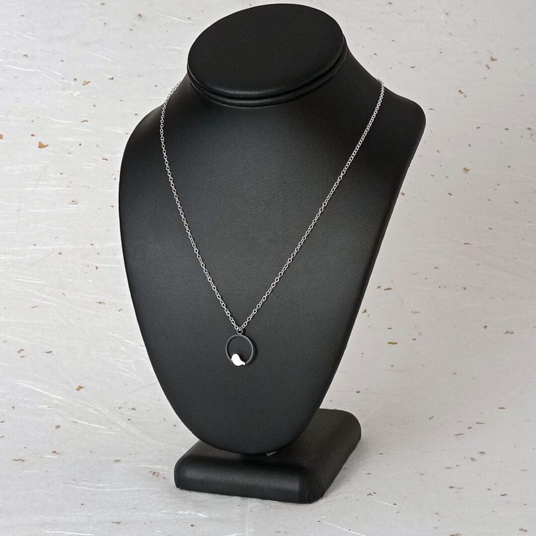 handmade oxidised sterling silver bird pendant necklace on stand