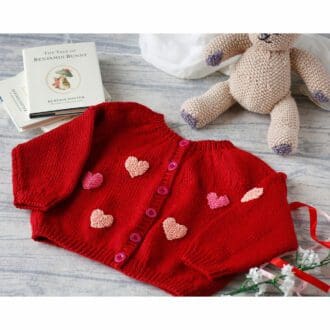 hand knitted baby cardigan in red decorated with pink hearts