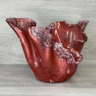 A red textured abstract sculptured bowl made from resin