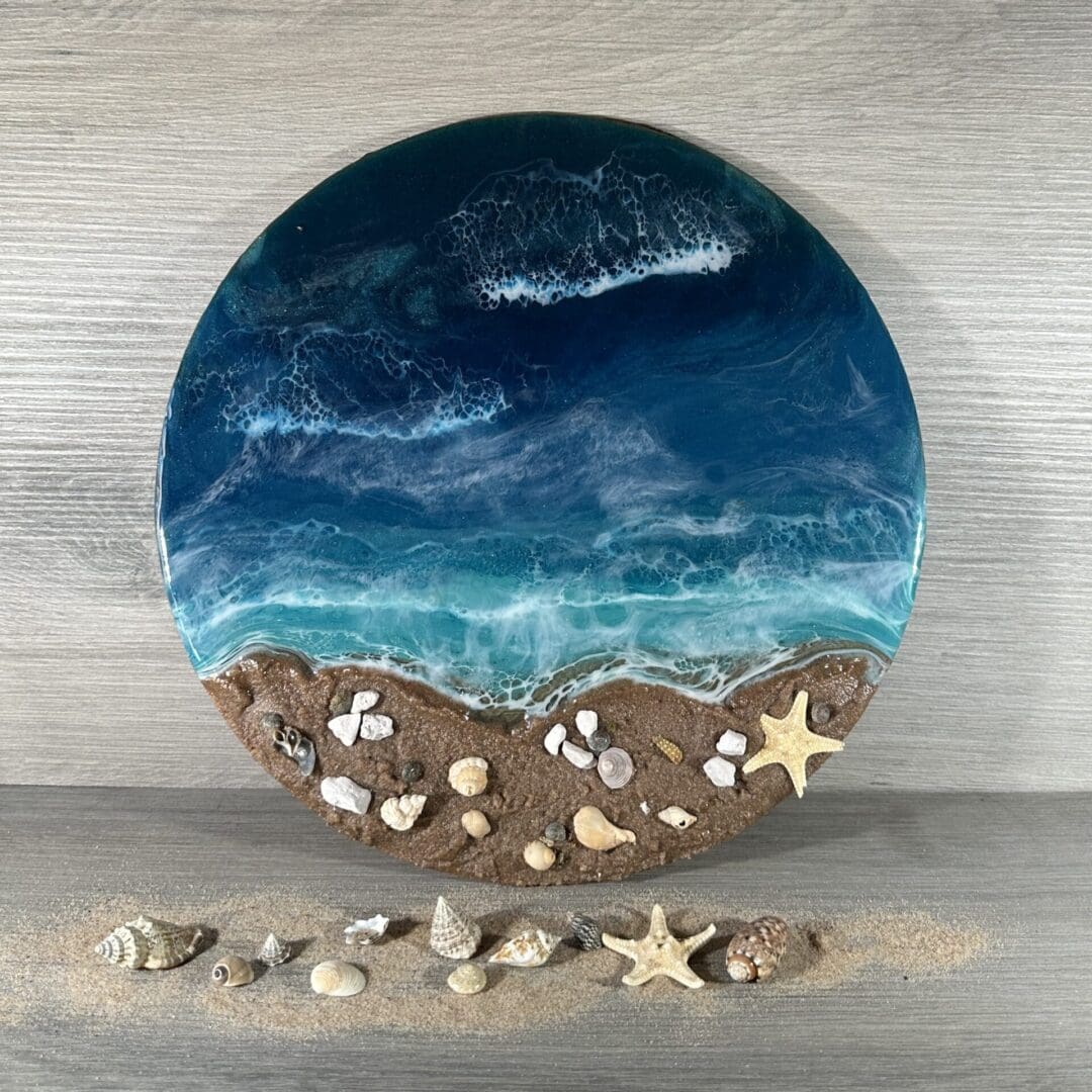 a 30cm round resin seascape with sand and shells