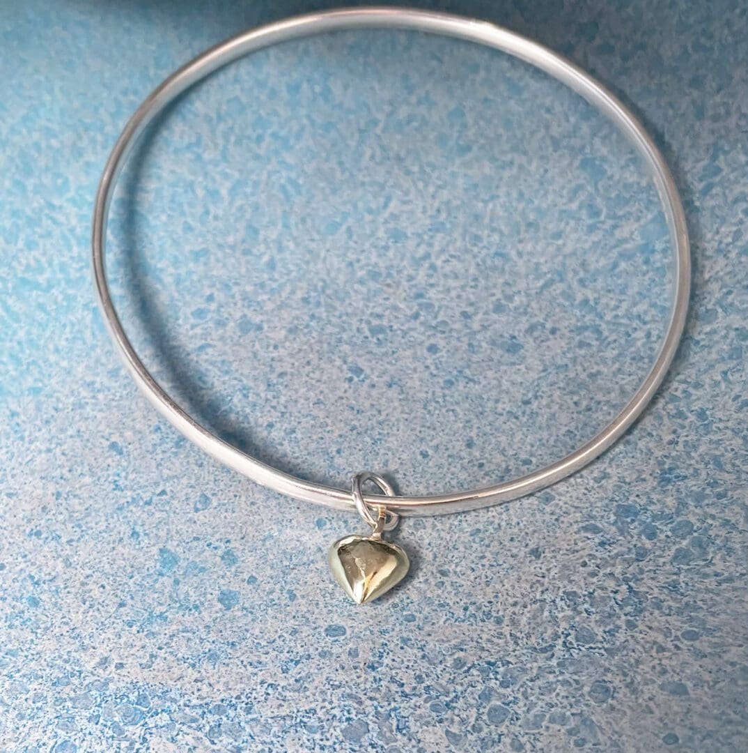 silver bangle and gold heart