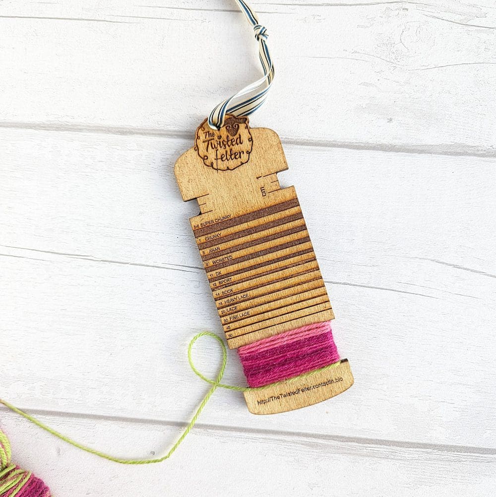 wooden yarn measuring tool wrapped with pink wool