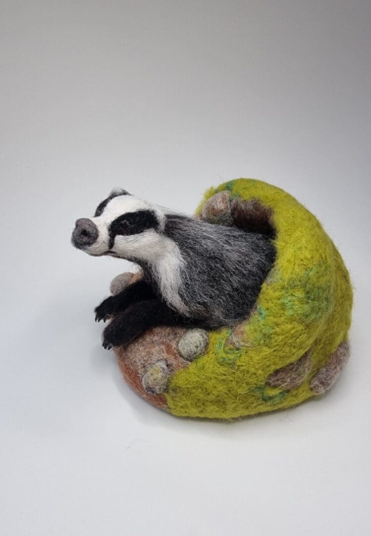 Needle felted Badger sculpture emerging from sett by Davina Brien- Two Little Hares Designs