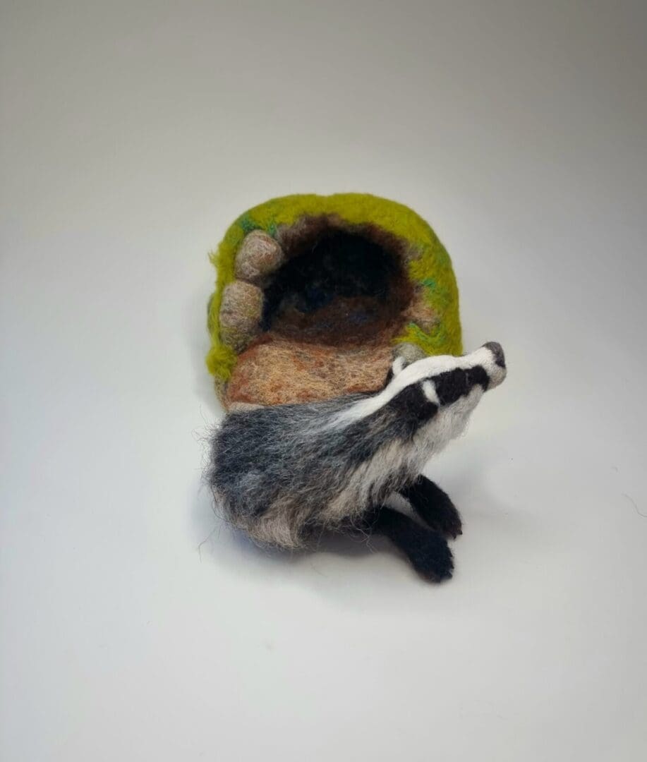 Needle felted Badger sculpture emerging from sett by Davina Brien- Two Little Hares Designs