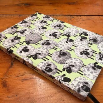 A5 handmade notebook with lined paper covered in a sheep design fabric