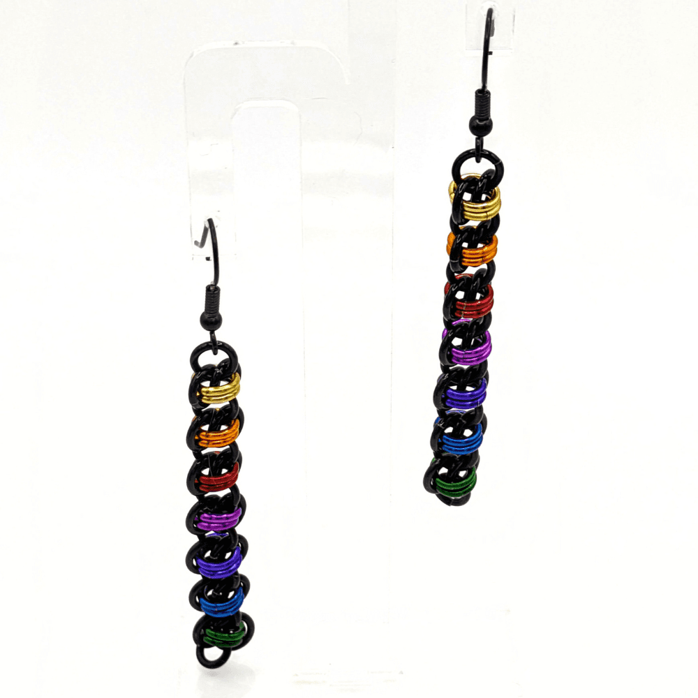 Long thin earrings made with black and rainbow coloured rings woven in the barrel weave. Finished with black stainless steel earwires