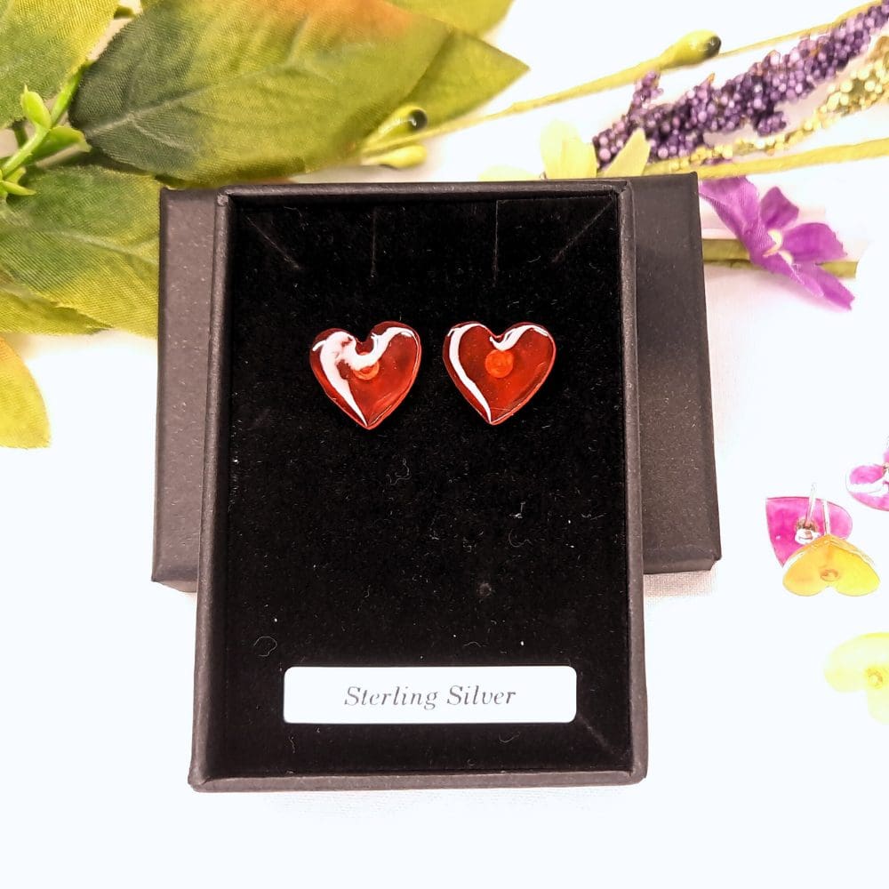 Little heart shaped earrings in a range of colours with a sterling silver stud fitting.
