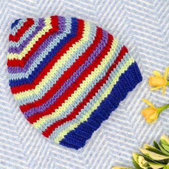Stripy pixie hat knitted from Debbie Bliss yarns, newborn to 12 months.
