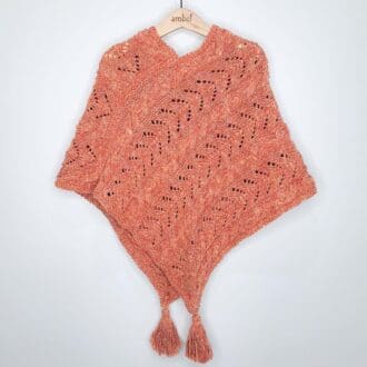 Beautiful hand-knitted cotton poncho in soft muted coral colour with tassels.