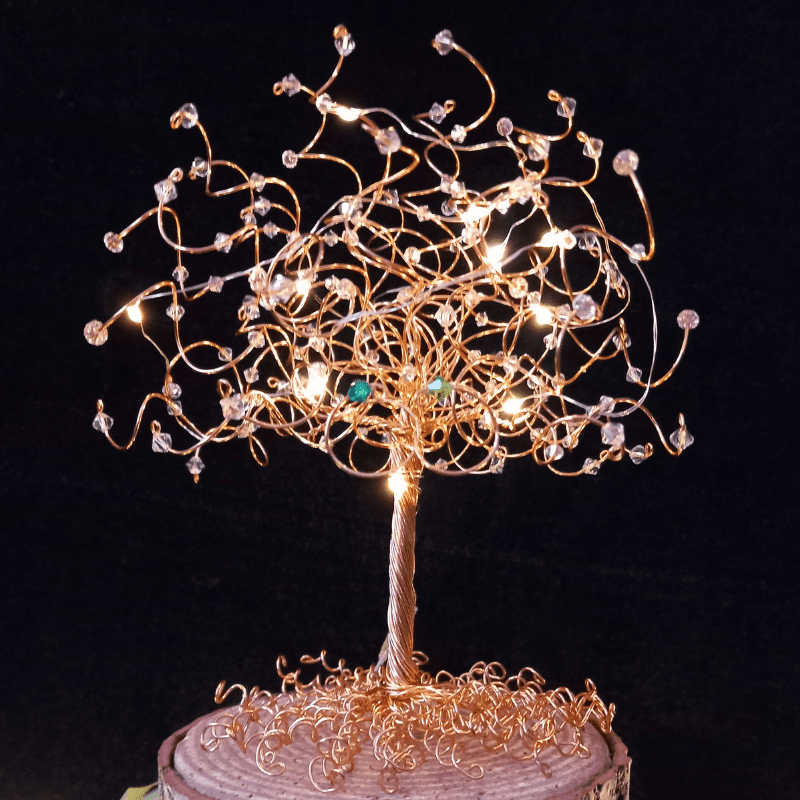 Close up photo of a gold wire & crystal tree cake topper lif with micro-lights