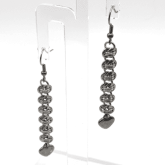 Earrings made from a section of barrel weave with a silver stainless steel heart hanging from the bottom.