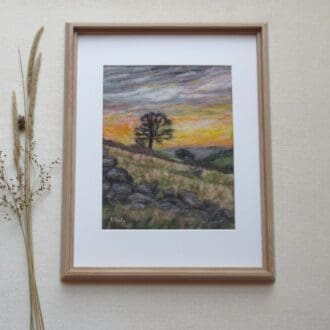 A handmade needle felted wool picture of a winter sunset over Yorkshire moorland in a light oak effect frame.